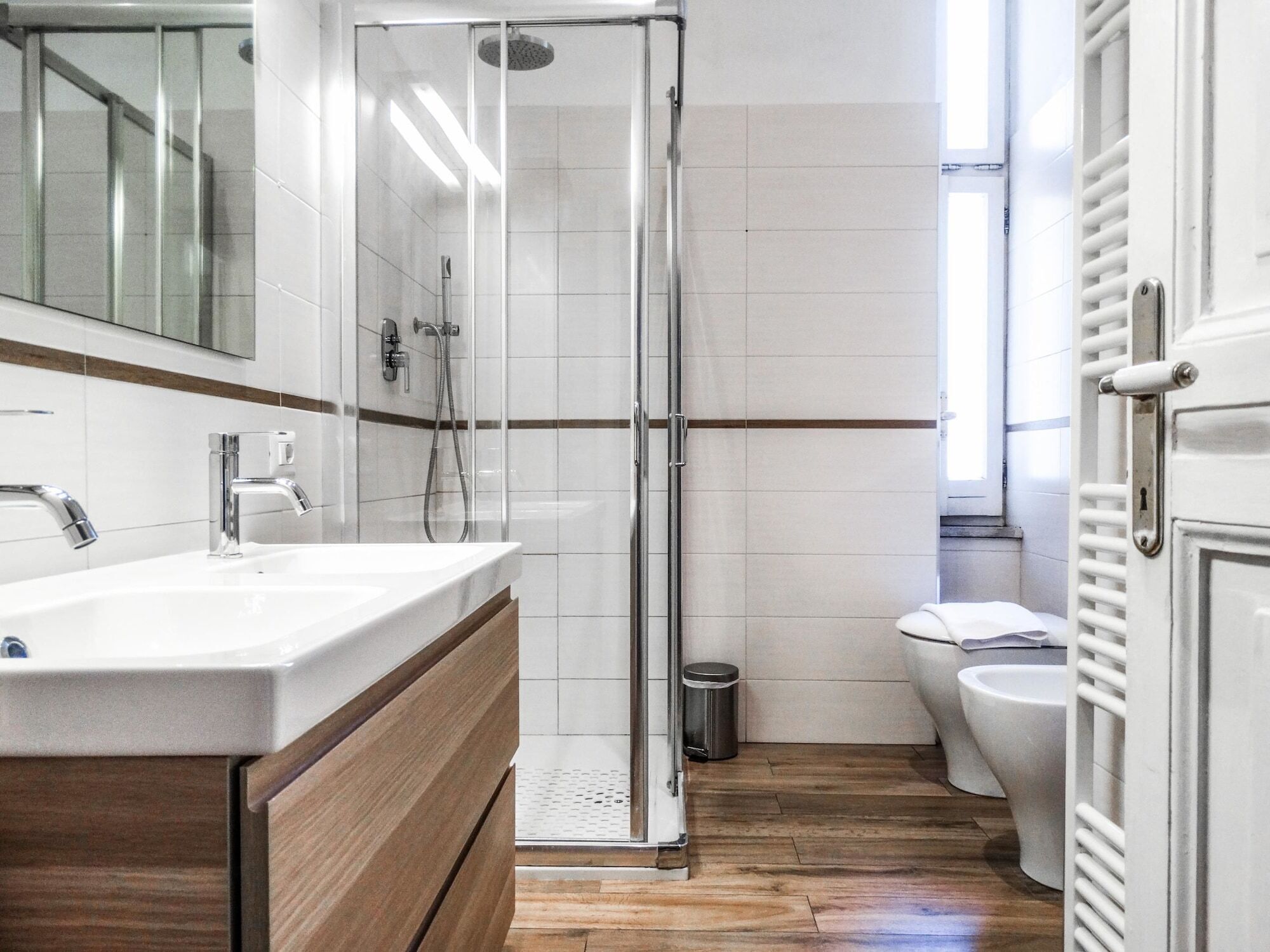 A modern bathroom with a glass shower enclosure, a white sink, and a toilet.