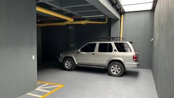 Eine Parkgarage mit einem einzelnen SUV in einem Platz, der mit gelben Linien gekennzeichnet ist.