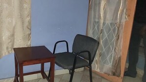 Ein kleines Zimmer mit einem Holztisch und einem schwarzen Stuhl.