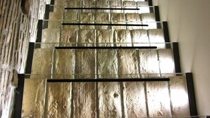 Una escalera con una pared texturizada a un lado y una pared lisa al otro.