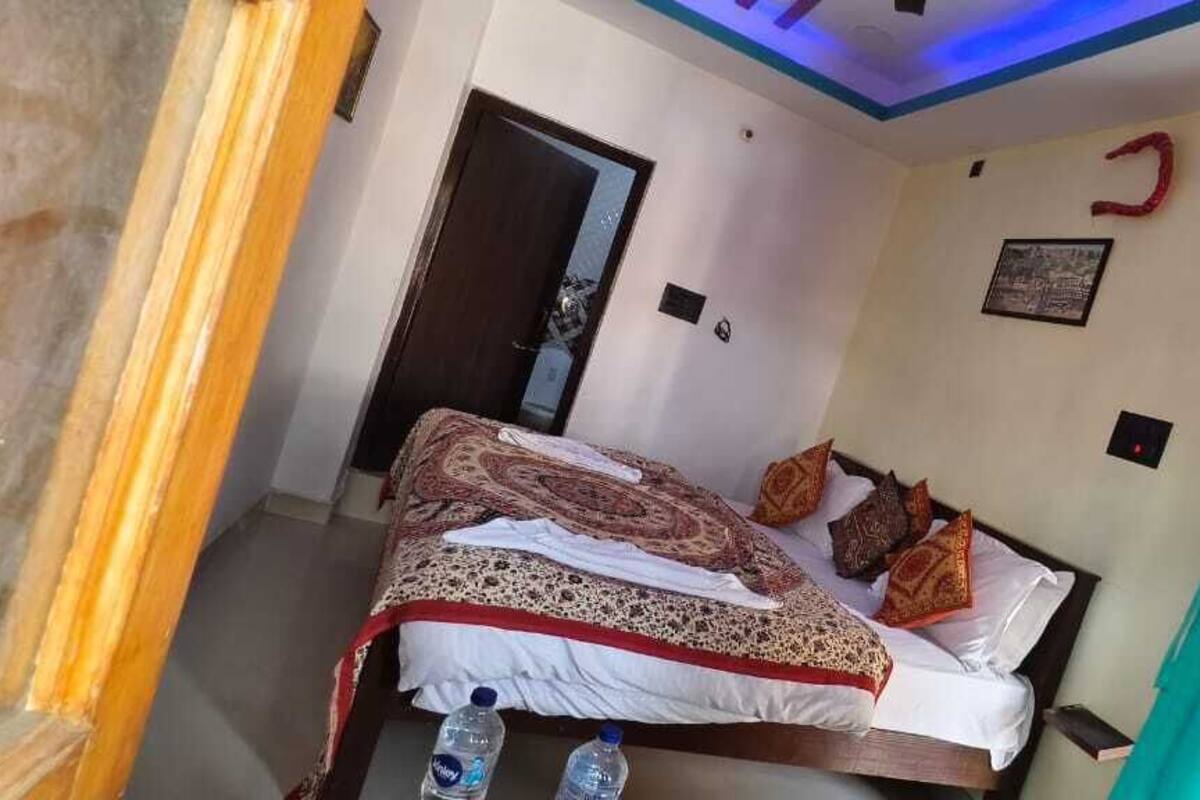 Ein Schlafzimmer mit einem Bett, Kissen, einer Wasserflasche und einer Tür.