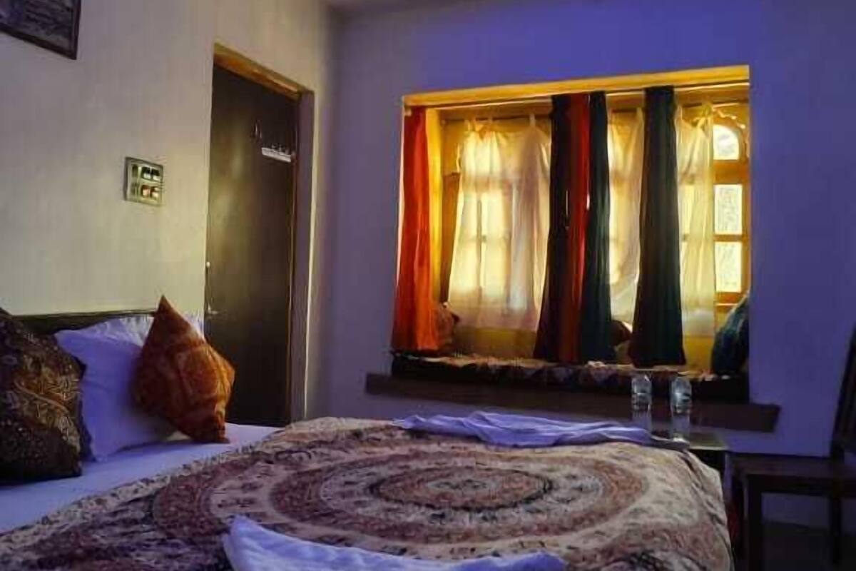 Ein Schlafzimmer mit Bett, Deckenventilator und einem Fenster mit Vorhängen.