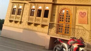 Un edificio de varios pisos con detalles arquitectónicos ornamentales, incluyendo balcones y ventanas decorativas.