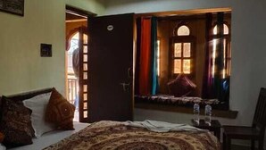 Un dormitorio con una cama grande, un ventilador de techo y vistas a un patio a través de una puerta abierta.