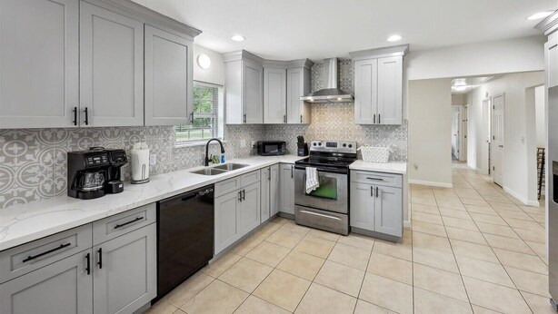 A modern kitchen with grey cabinets, a built-in oven, a microwave, and a coffee maker. - 4 bedroom home in Bridge City (Bridge City)