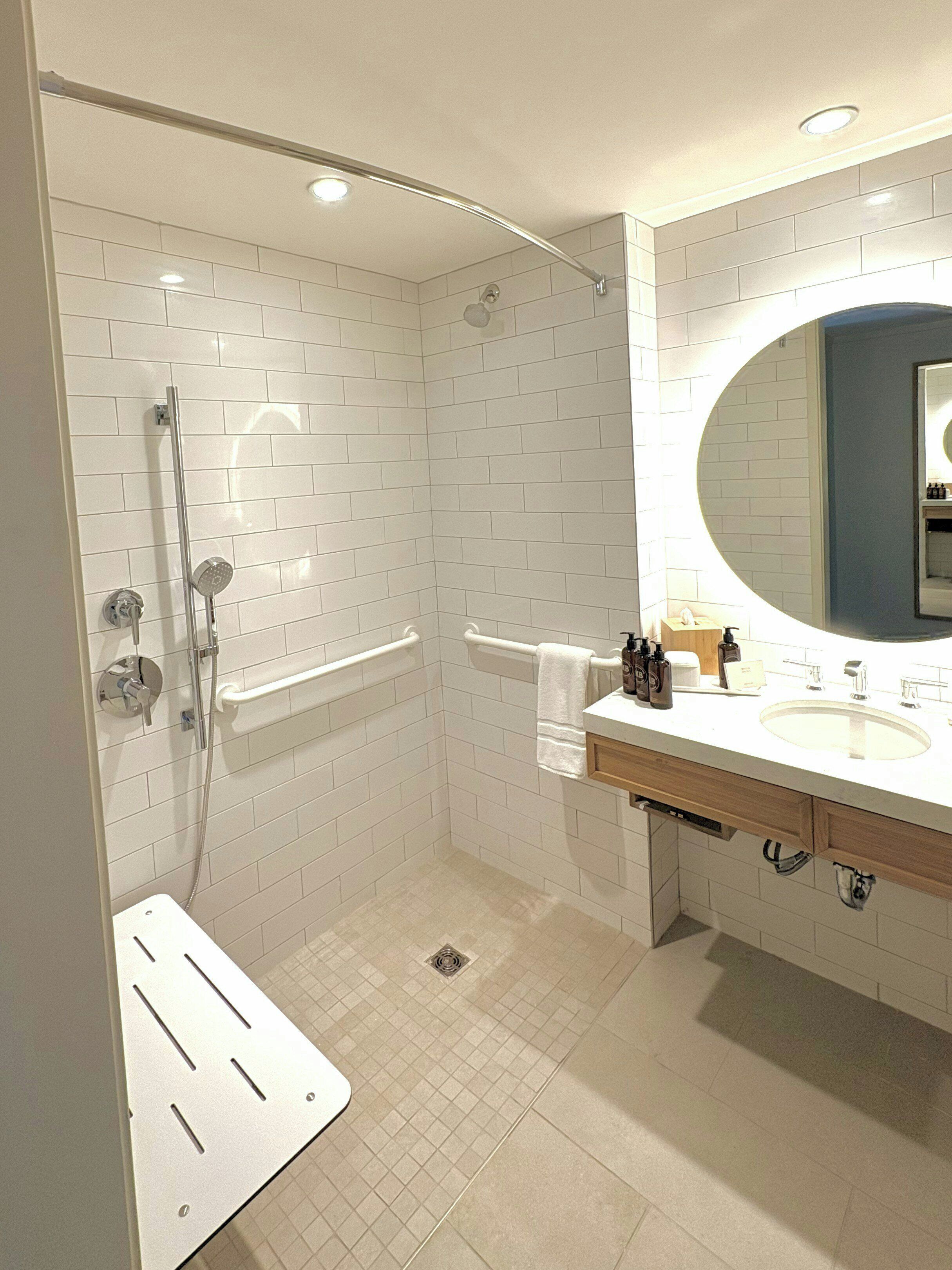 A modern bathroom with a walk-in shower, a bathtub, and a vanity with a mirror.