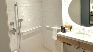 Une salle de bain moderne dotée d’une douche à l’italienne, d’une baignoire et d’un meuble-lavabo avec un miroir.