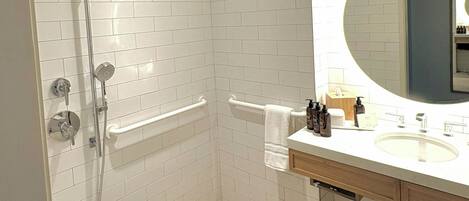 A modern bathroom with a walk-in shower, a bathtub, and a vanity with a mirror.