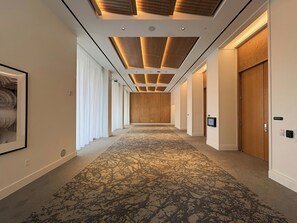 A hotel hallway with patterned carpet, wooden doors, and a ceiling with recessed lighting. - Virginia Guesthouse Hotel (Charlottesville)