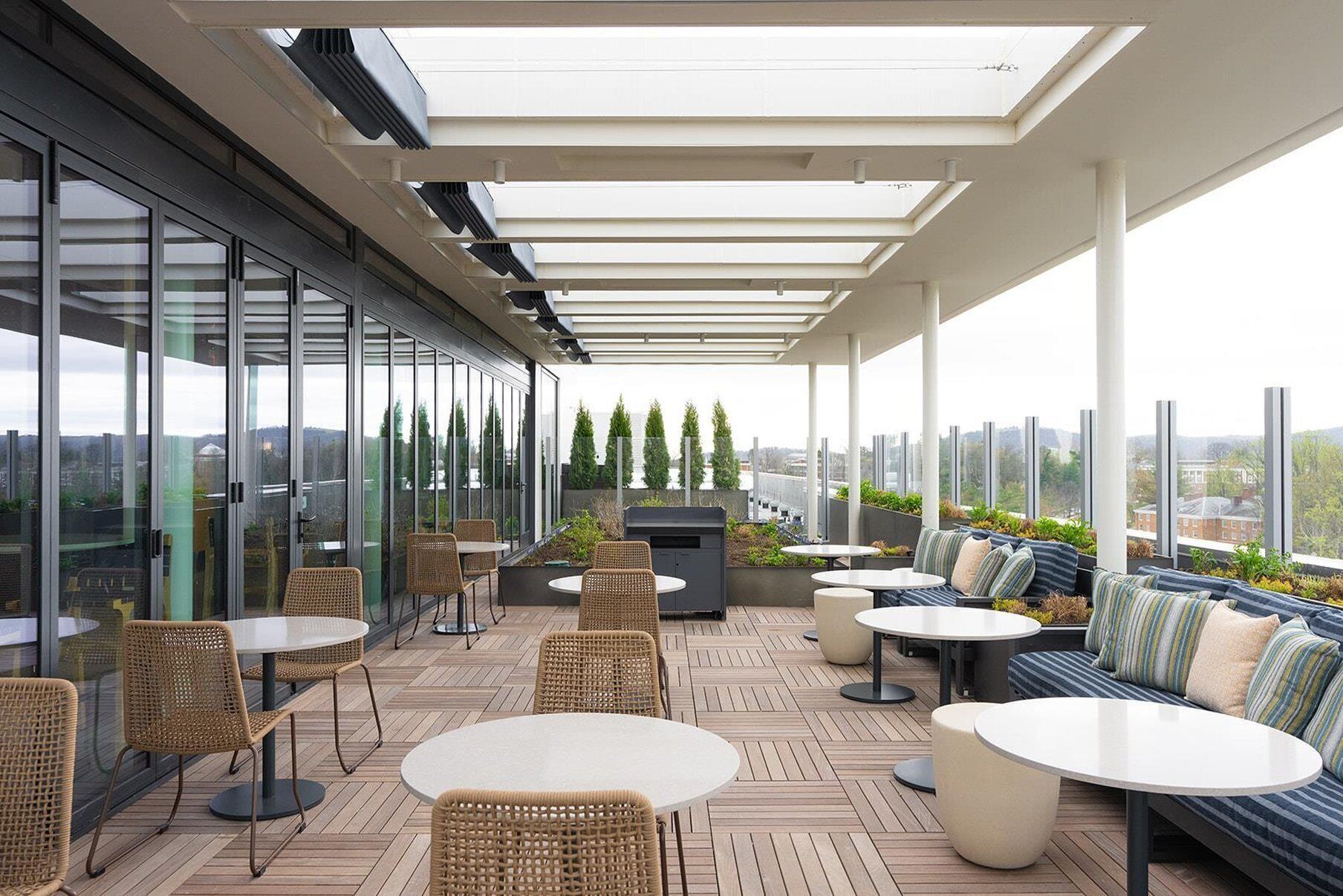 An outdoor patio with tables and chairs, a sofa, and a grill.