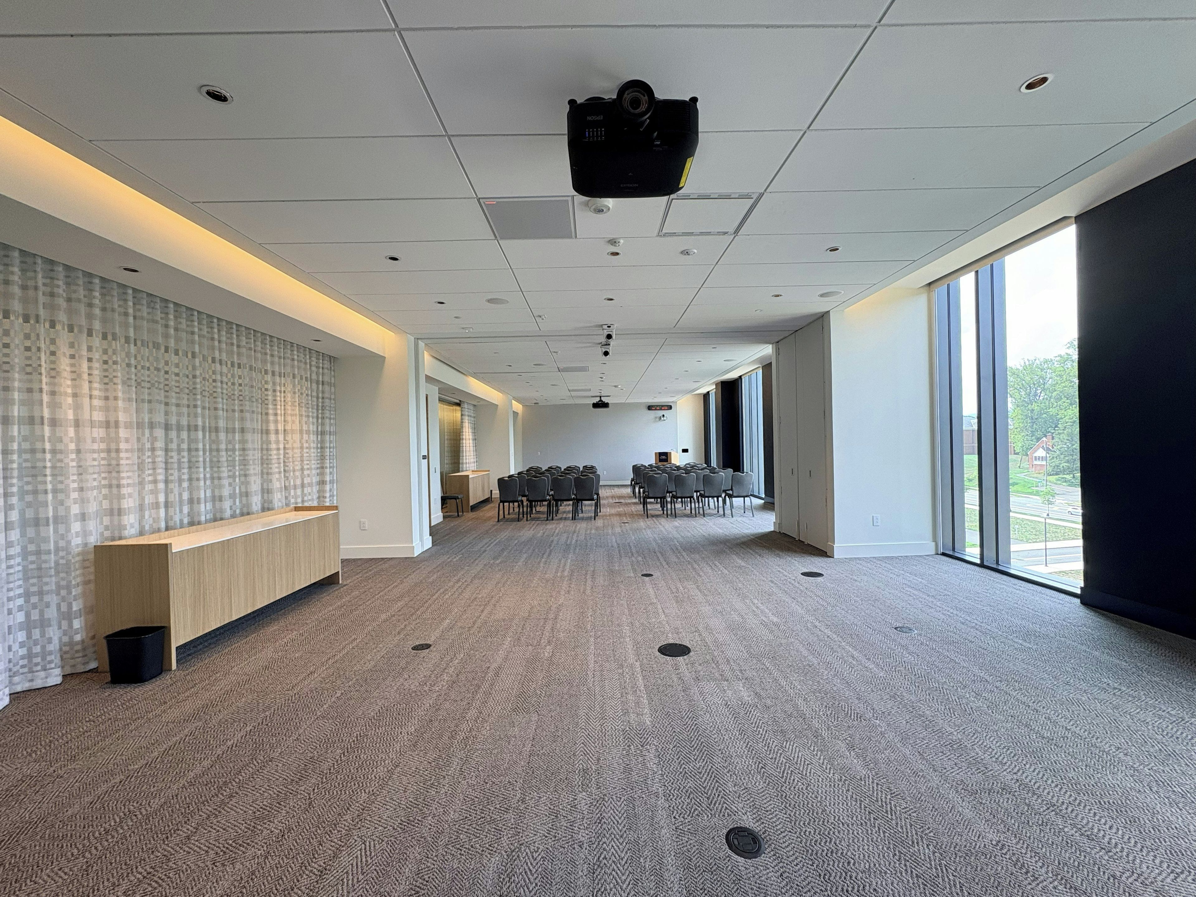 A conference room with a long table, chairs, and a projector.