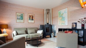 Un salón con sofá, una mesa de centro, chimenea y un mapa en la pared.