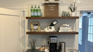 A kitchen with a coffee maker, a bottle of Pellegrino water, and a framed photo on the counter. - Spacious Historical 6-bed house in Princeton. Pool, bocce and basketball court. (Princeton)