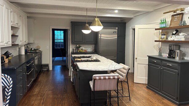 A modern kitchen with a central island, dark cabinetry, and a stainless steel refrigerator. - Spacious Historical 6-bed house in Princeton. Pool, bocce and basketball court. (Princeton)