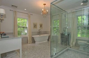 A bathroom with a freestanding bathtub, a glass shower enclosure, and a vanity with a mirror. - Spacious Historical 6-bed house in Princeton. Pool, bocce and basketball court. (Princeton)