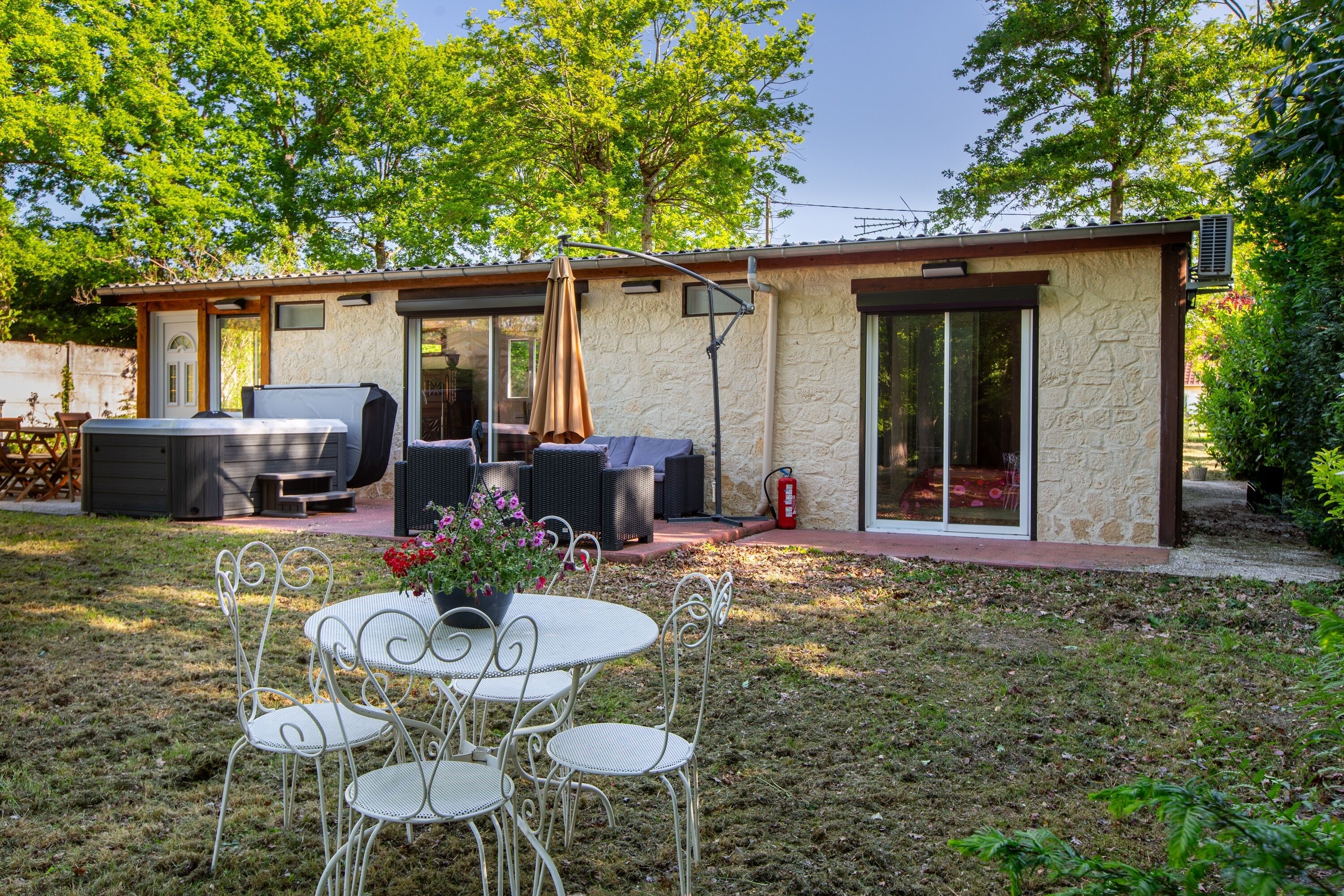 A patio with a table and chairs, a barbecue grill, and outdoor seating.