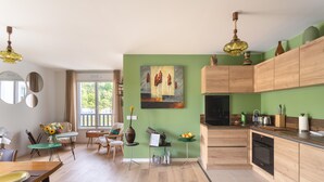 Eine moderne Küche mit Holzausstattung, einem Einbauofen und einem Essbereich mit Tisch und Stühlen.
