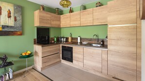 Eine moderne Küche mit Holzausstattung, einem eingebauten Ofen und einer grünen Wand.