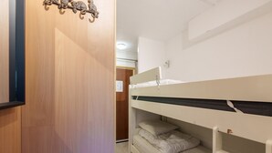 Een stapelbed met een houten deur en een decoratie aan de muur.