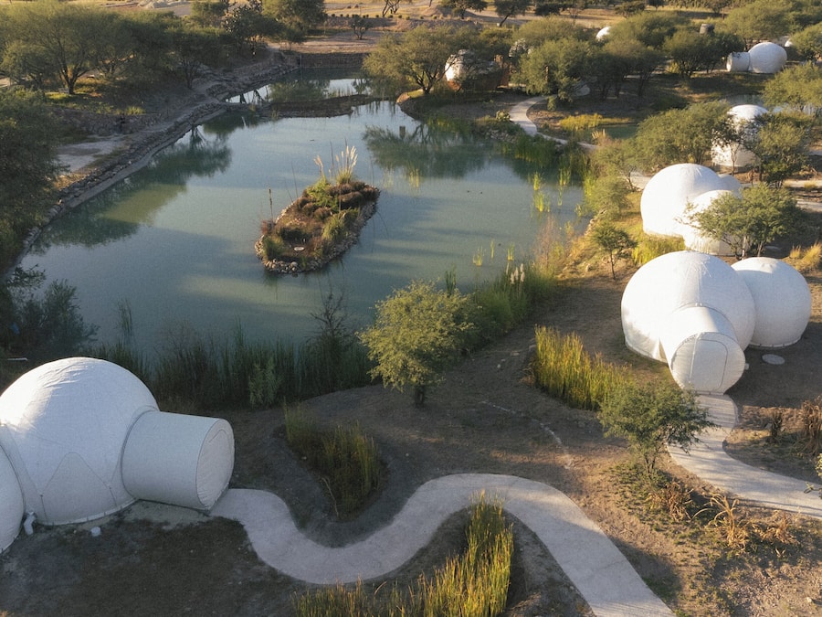 A landscaped area with a pond, spherical structures, and a winding path.