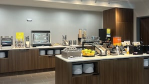 A modern breakfast bar with a variety of food and drink options, including a coffee machine and a waffle station. - Home2 Suites By Hilton Bastrop, Tx (Bastrop)
