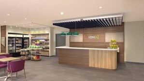 Un interior moderno con mostrador de recepción, barra de aperitivos y zona de estar.
