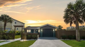 A residential house with a garage, a driveway, and a well-maintained lawn.