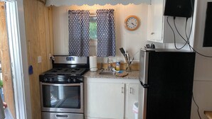 A compact kitchen with a stove, oven, sink, and a refrigerator. - Spotted Sandpiper - Cabin #3 (Trumansburg)