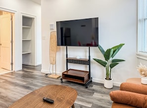 Relax in this stylish living room with a flat-screen TV, coffee table, and comfortable seating area.