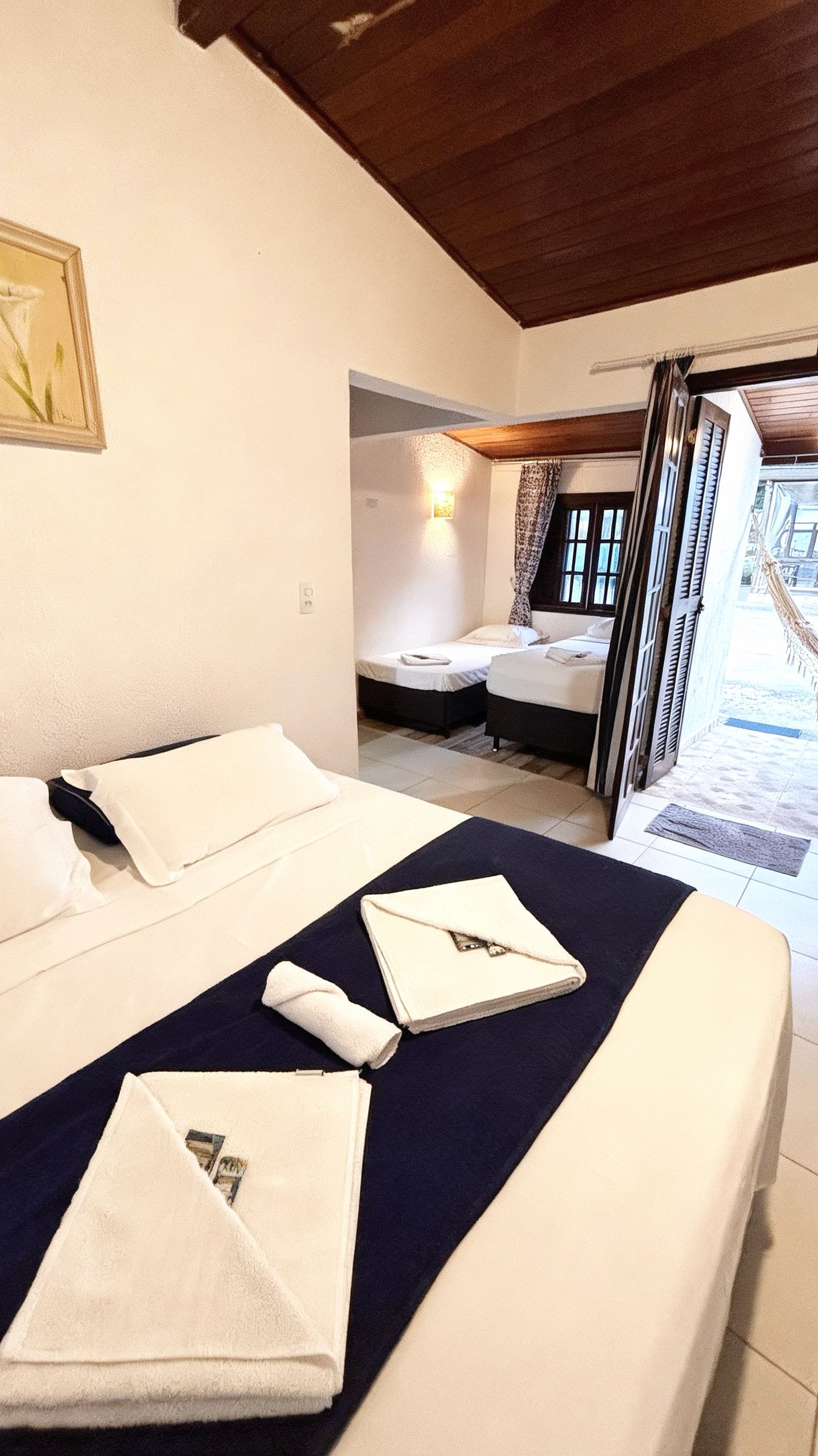 Une chambre d’hôtel avec deux lits, un tableau au mur et une vue sur l’extérieur.