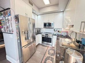 Een moderne keuken met roestvrijstalen apparatuur, een magnetron en een inbouwoven.