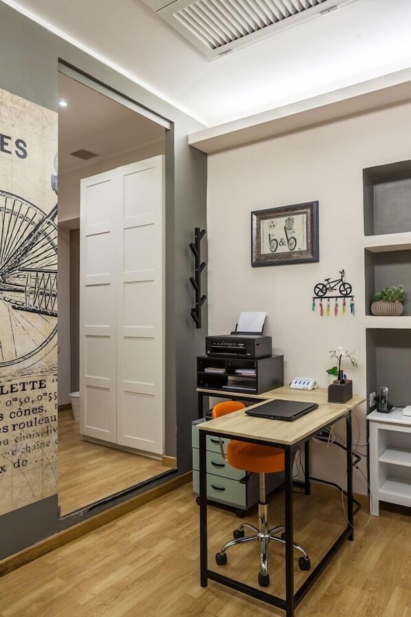 A modern office space with a desk, chair, printer, and shelves. - Bed&bicycle Guesthouse (Rome)