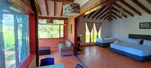 A room with a bed, a chair, a small table, and a window with curtains. - Hotel Campestre La Martina (Rionegro)