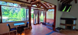 A room with a large window, a fireplace, and a TV mounted on the wall. - Hotel Campestre La Martina (Rionegro)