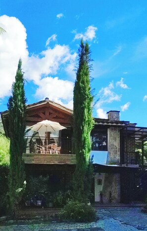 A wooden gazebo with a table and chairs, surrounded by tall trees. - Hotel Campestre La Martina (Rionegro)