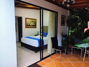 Un dormitorio con cama, una silla y un cuadro en la pared.