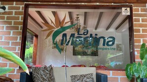 Un rincón acogedor con un sofá y cojines, una estatua decorativa de un elefante, y una ventana con el letrero "La Martina".