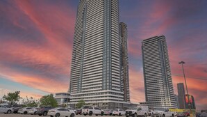 Ein modernes Hochhaus mit markantem architektonischen Design, das durch eine Reihe horizontaler Linien und einen ausgeprägten, zentralen Kern gekennzeichnet ist.