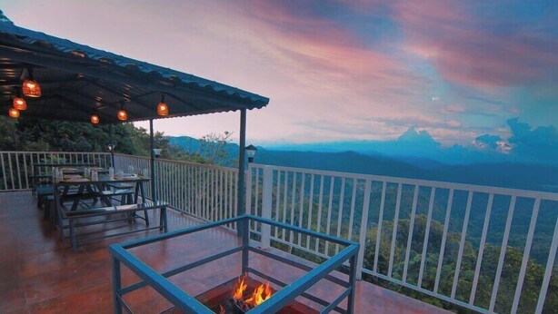 Une terrasse dotée d’un foyer extérieur, de sièges confortables et offrant une vue panoramique sur les montagnes.