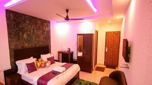 Une chambre à coucher comprenant un lit, une table de chevet, une commode et un ventilateur de plafond.