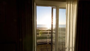 A room with a sliding glass door leading to a balcony with a metal railing. - Portmarnock Hotel And Golf Links (Portmarnock)