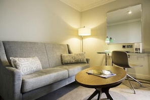 Relax in a stylish space with a grey sofa, armchair, and flat-screen TV.