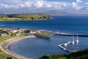 Une ville côtière dotée d’un port de plaisance, de maisons et offrant une vue dégagée sur la mer.