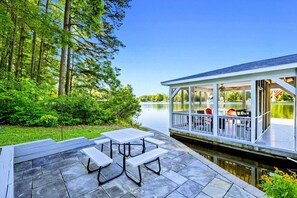 A lakeside deck with picnic tables, a covered seating area, and a view of the lake. - Lakefront Lake Anna, Fire Pit, Pool, Beach (Mineral)