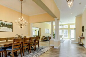 A spacious dining area with a chandelier, wooden dining table, and chairs. - Lakefront Lake Anna, Fire Pit, Pool, Beach (Mineral)