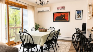 Een eetruimte met een tafel, stoelen, een kroonluchter en een bordje met de tekst 'Welcome to the Ski-Lodge'.