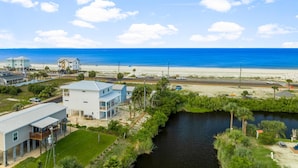 A coastal property with a view of the ocean, a small waterway, and a road leading to the beach. - Beach House - Even Keel by PHG (Mexico Beach)