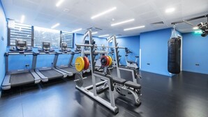 A gym with treadmills, weight machines, and a punching bag.