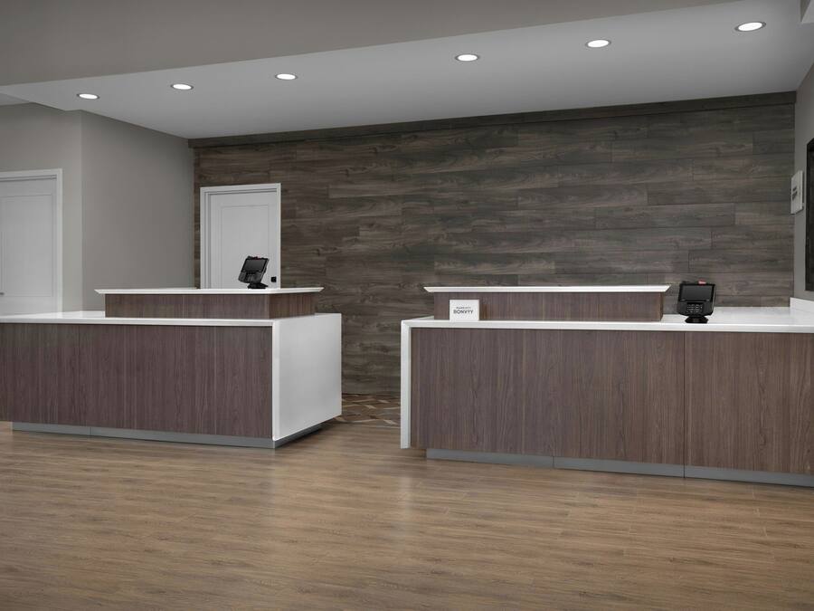 A reception area with two reception desks, a wooden wall, and a door.