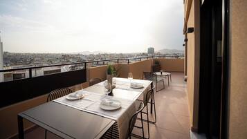 A dining area with a table set for two, overlooking a cityscape.